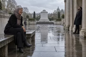 Two laughing memorial-design researchers at a fictional National Muslim War Memorial competition 2026 garden